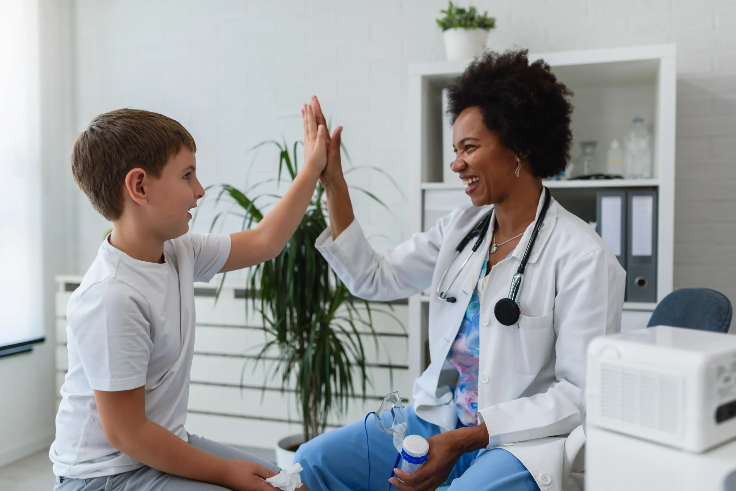 Doctor high fiving a child in a doctor's office