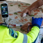 Community paramedic holding the hand of a client in their home. 