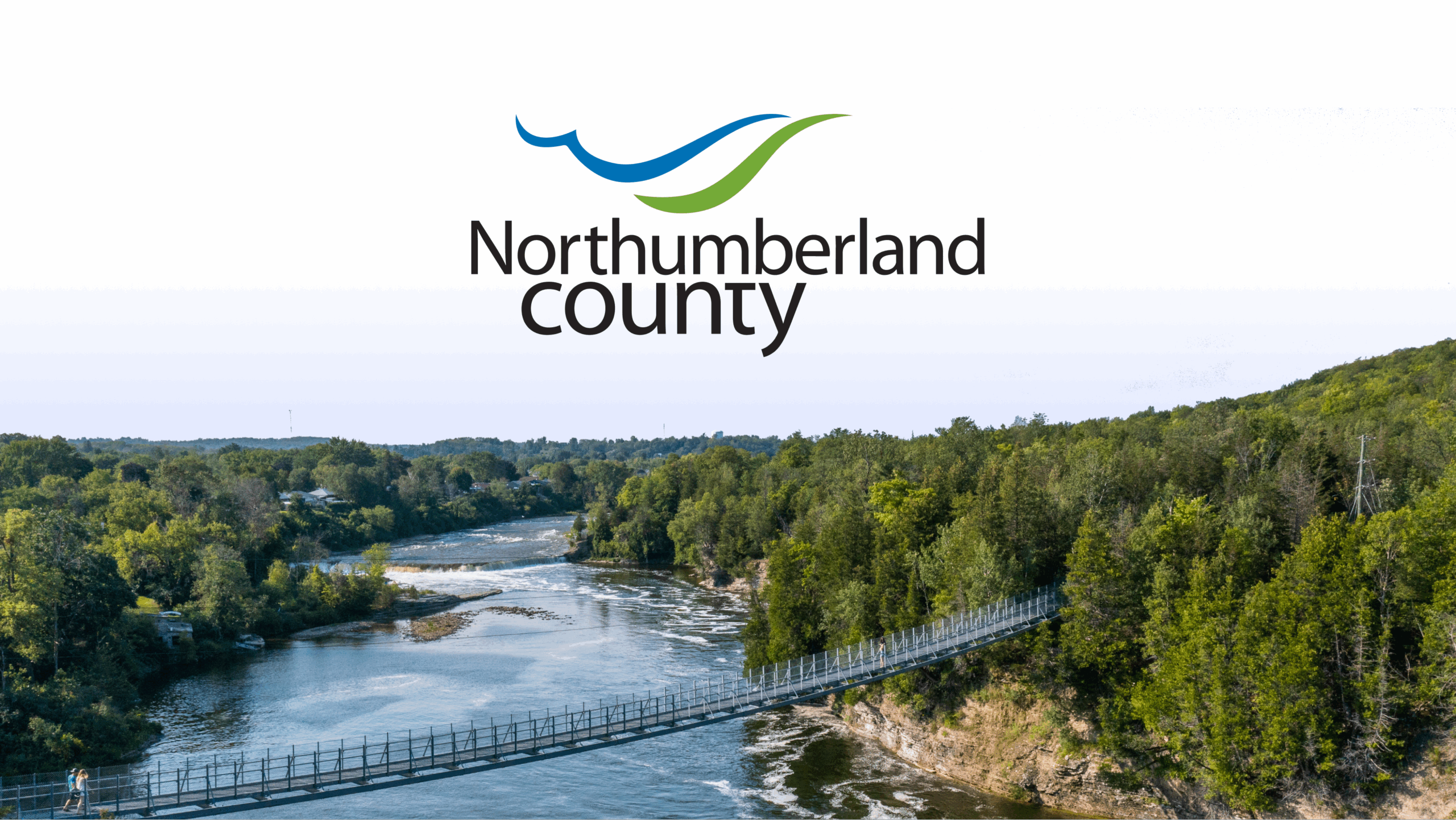 Aerial image of a suspension bridge in the County. The Northumberland County logo is in the upper area of the image.