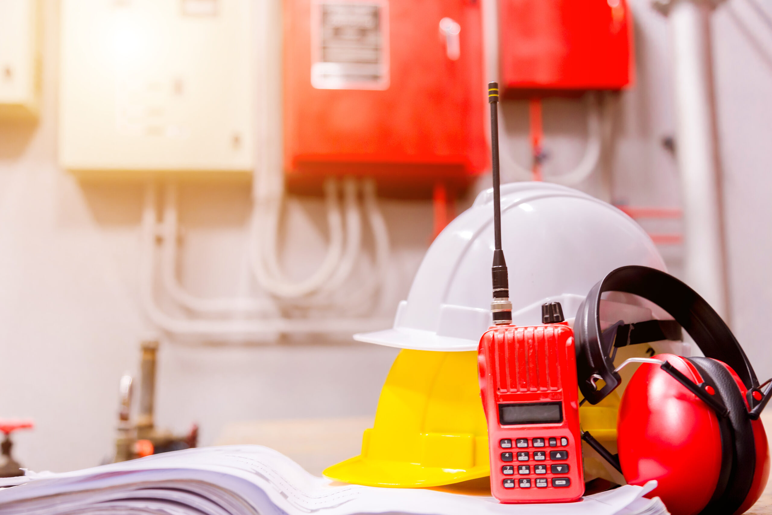 Safety equipment including walkie talkie, two hard hats and ear protection