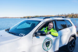 Community Paramedic sitting in a paramedic vehicle by the lake.