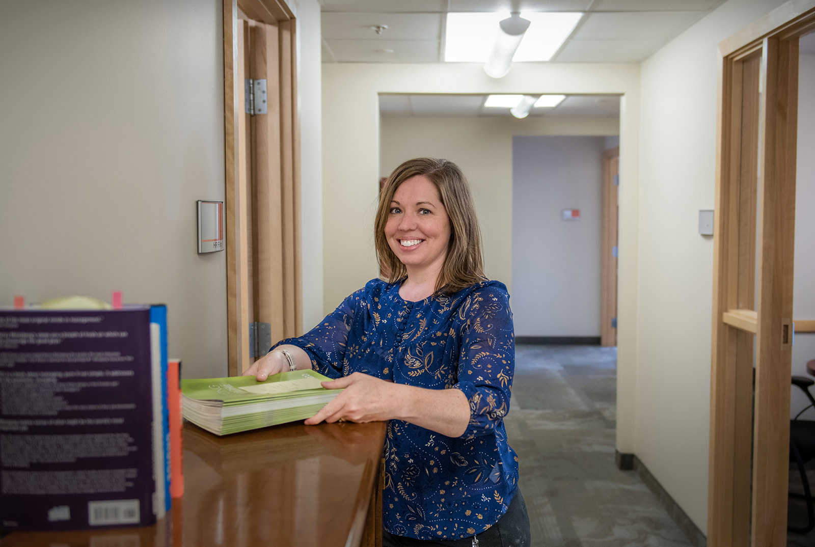 County staff smiles as they pick up papers from counter