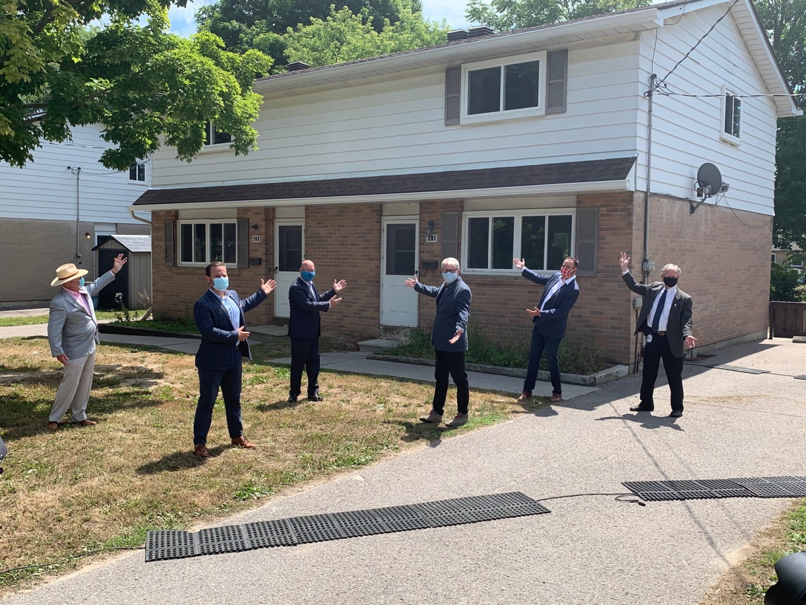 Government officials standing in front of the one of the Elgin Park homes.