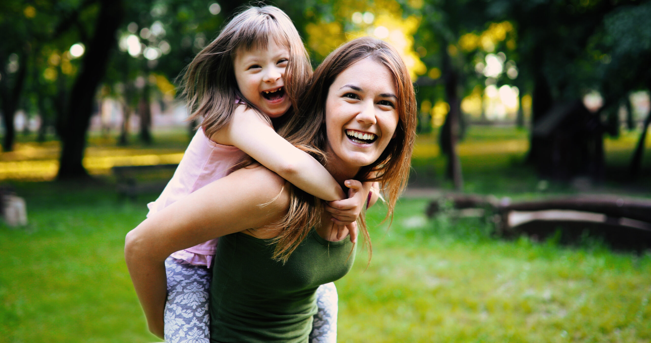 Mother carries little girl with special needs on her back