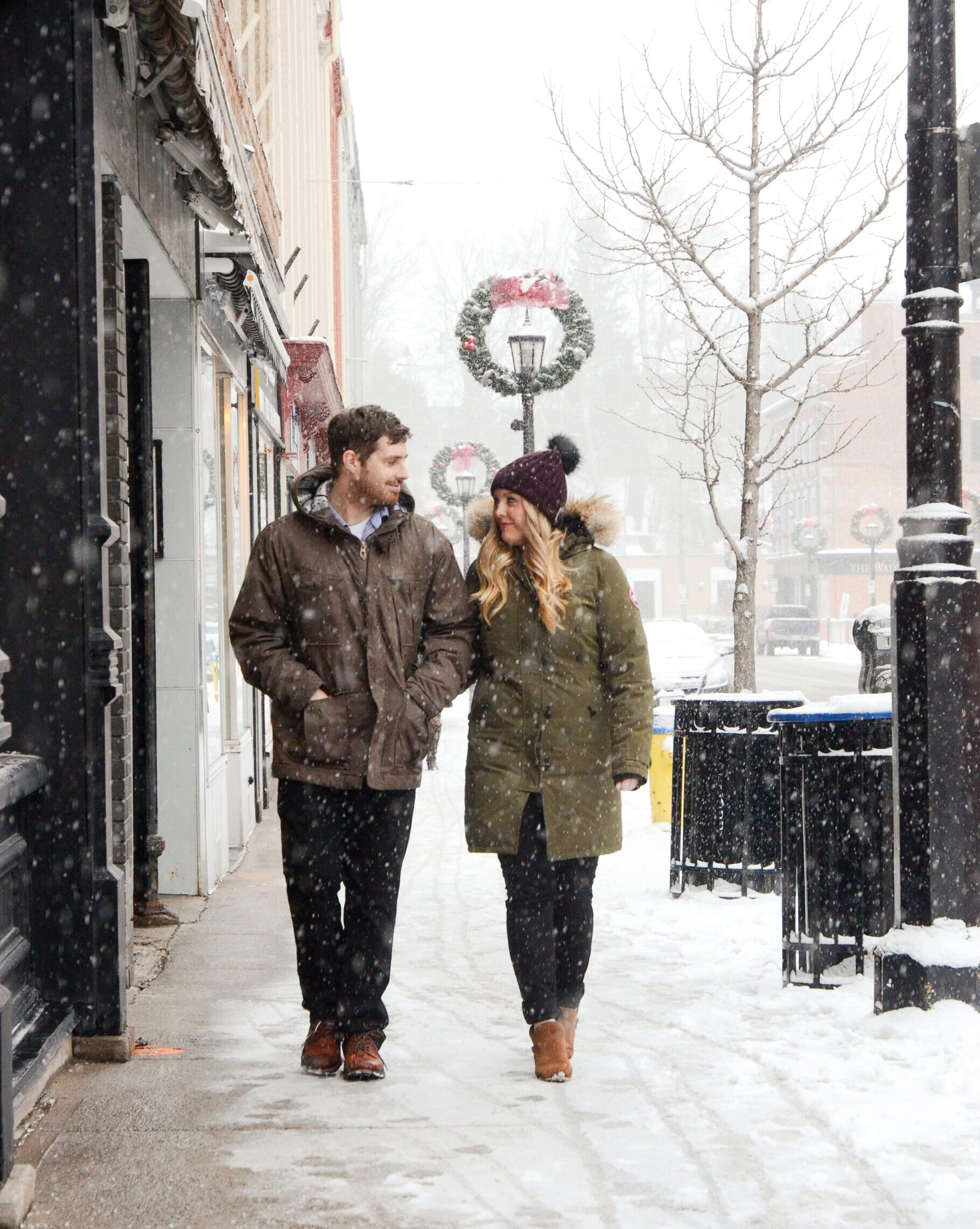 Couple shops downtown as the snow falls down