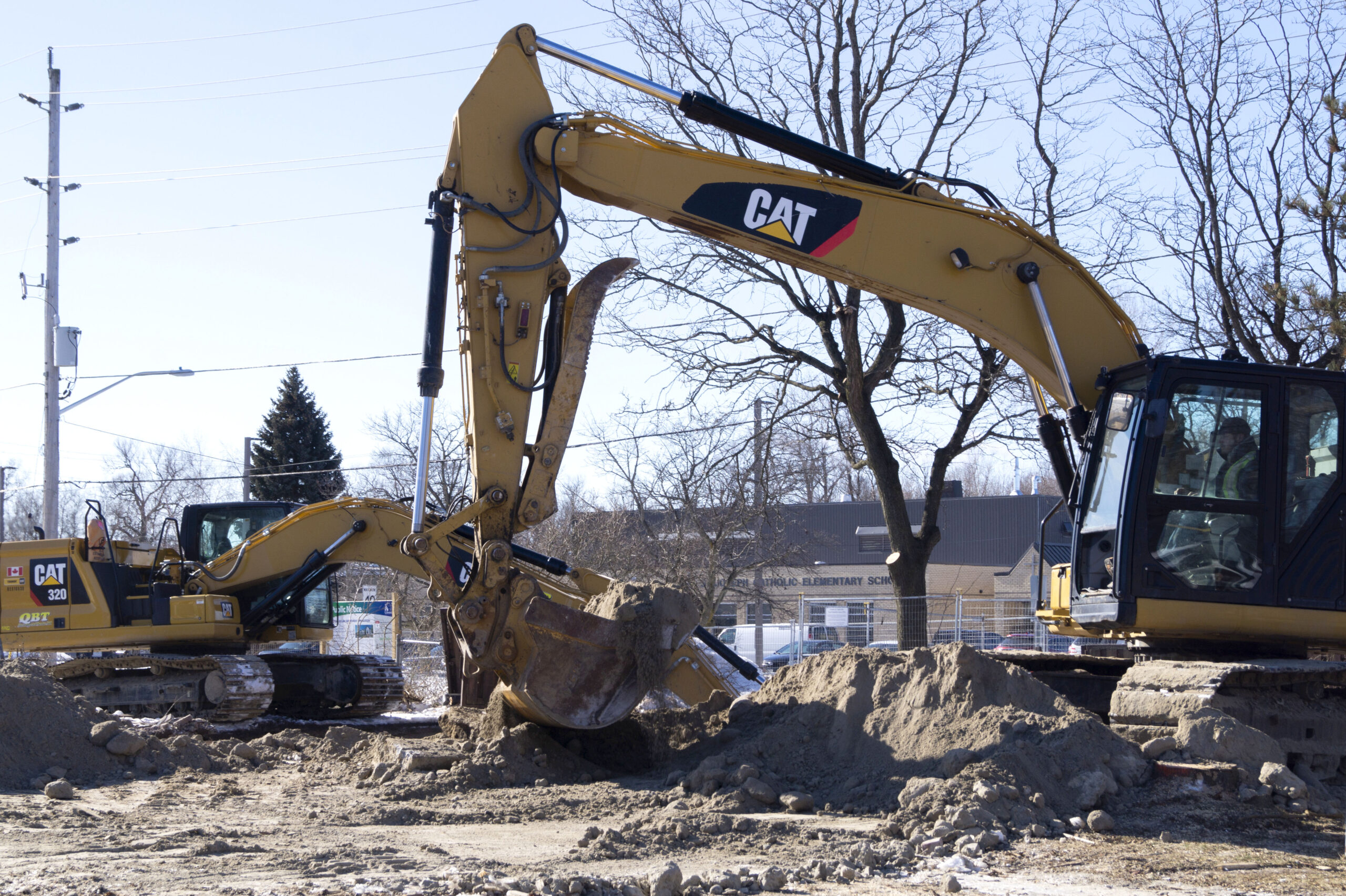 Two large pieces of digging equipment working on a site.