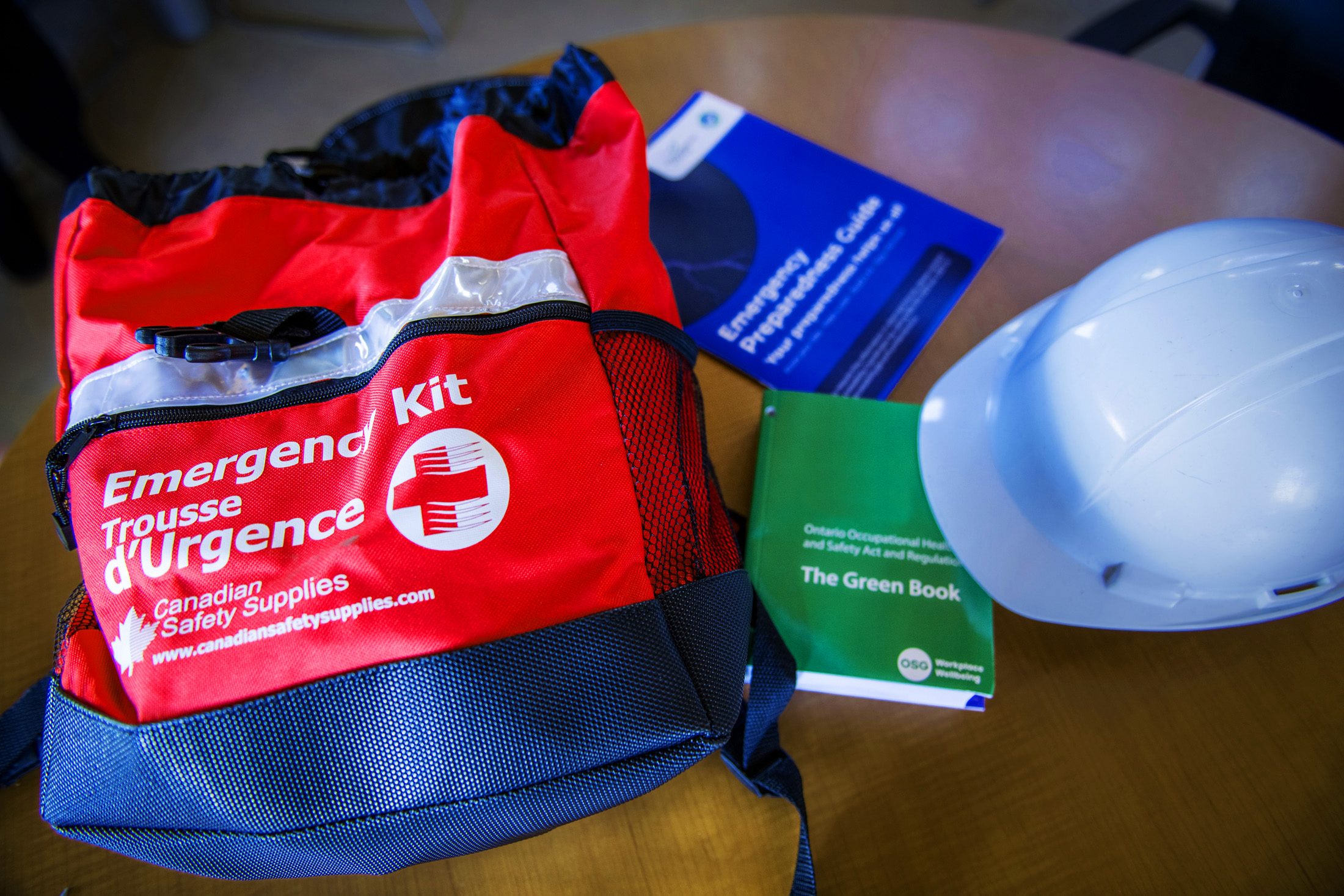 Emergency preparedness kit, hard hat and Northumberland County's Emergency Preparedness Guide displayed on a wooden table.