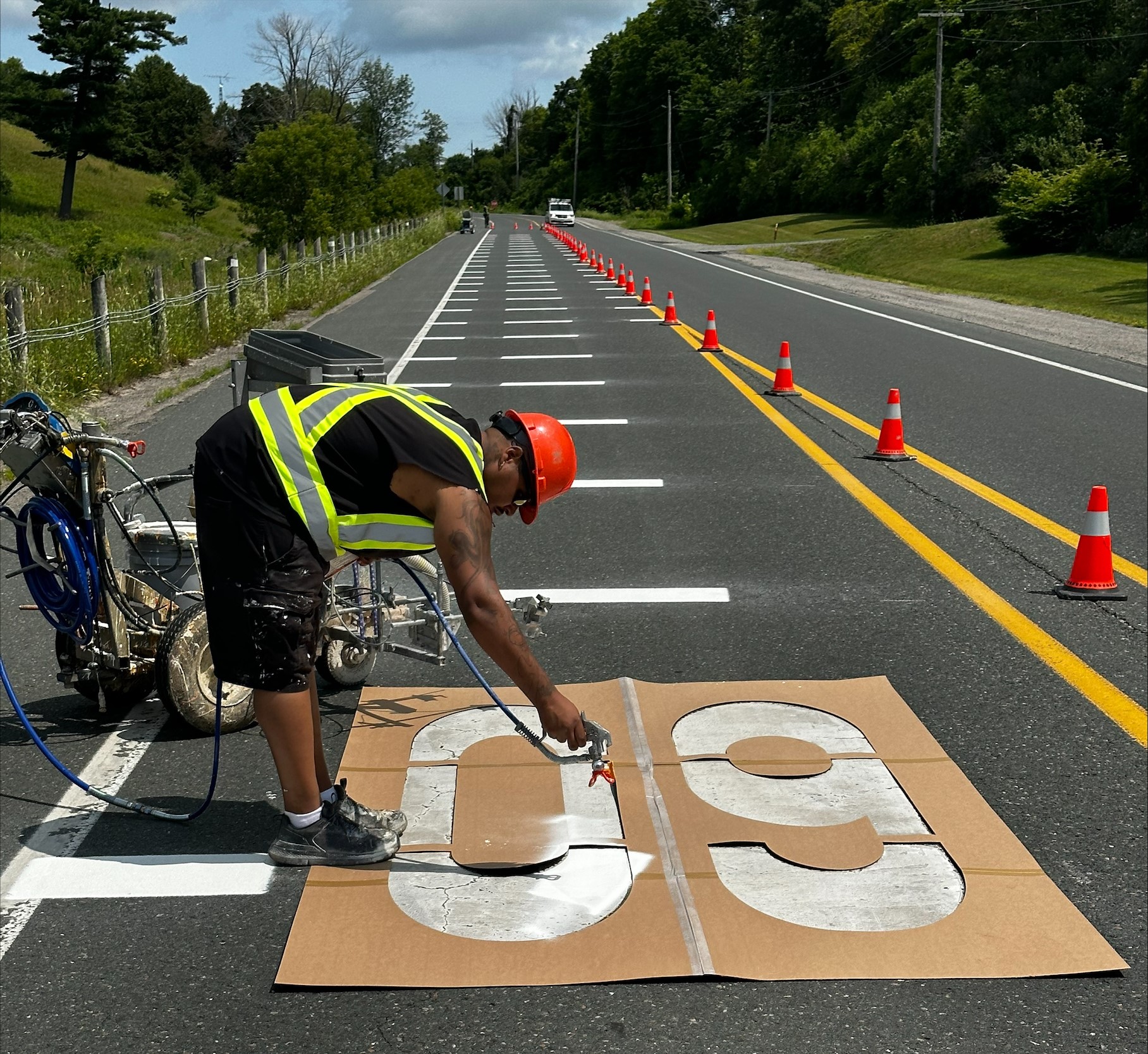 Public Works professional painting road markers on a County Road.