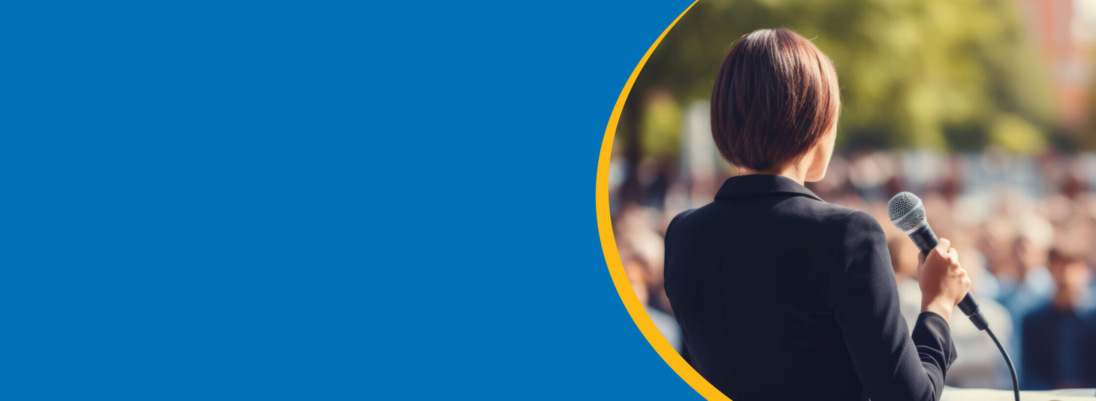 Candidate speaks to crowd with microphone, while standing at a podium on stage