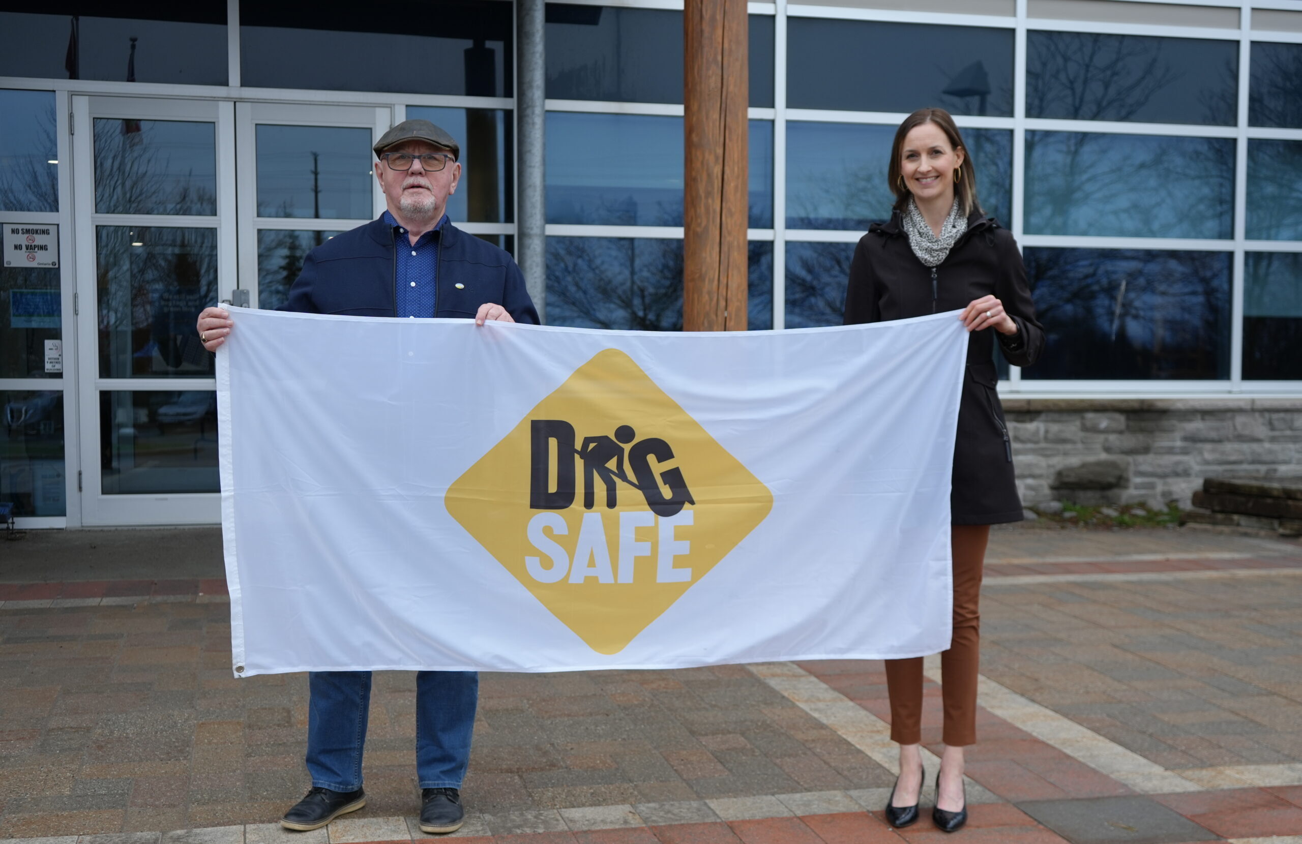 Northumberland County Warden Bob Crate and Director of Public Works Denise Marshall holding the Dig Safe Month flag outside of County headquarters.