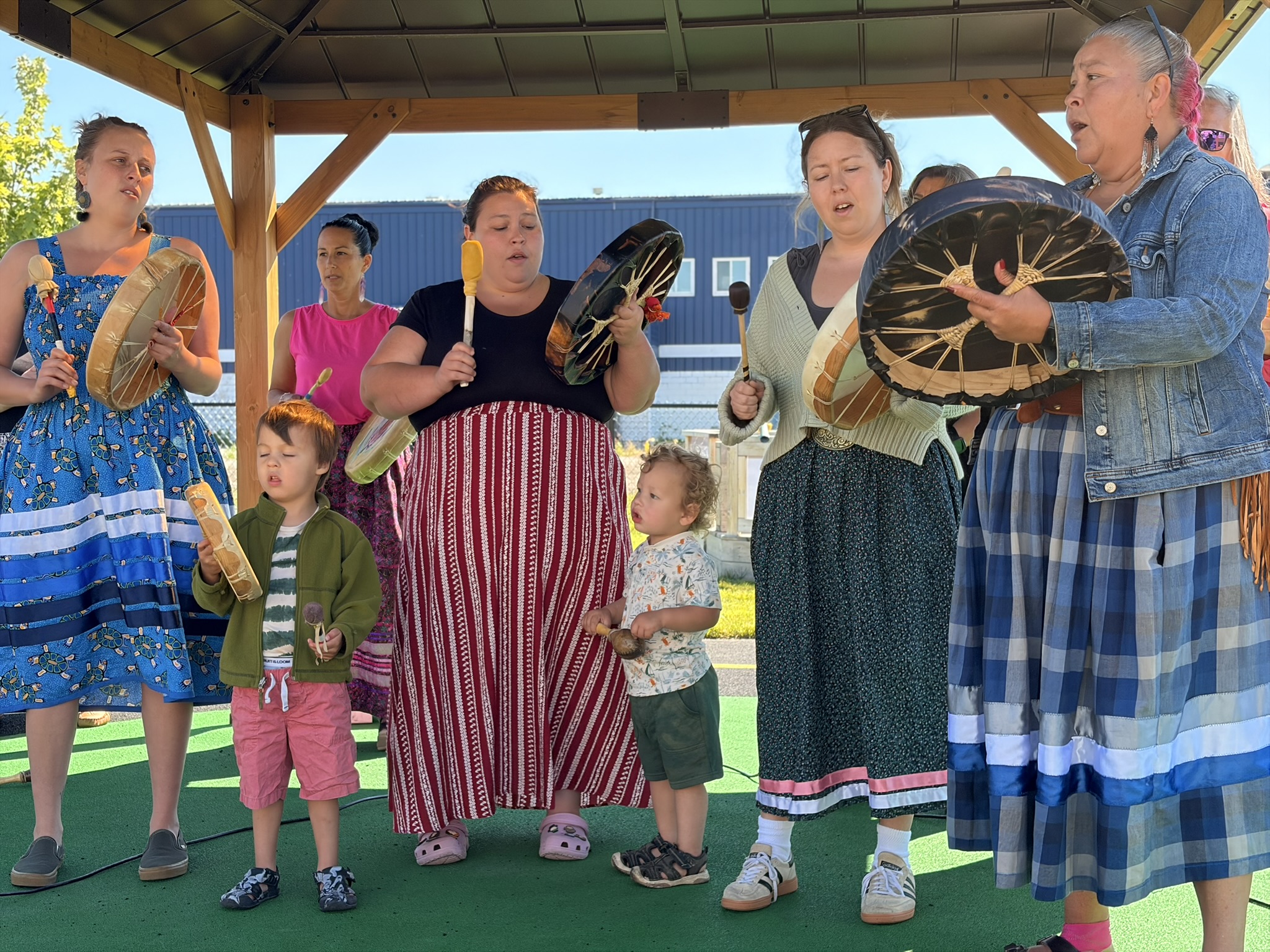 Children and adults drum together