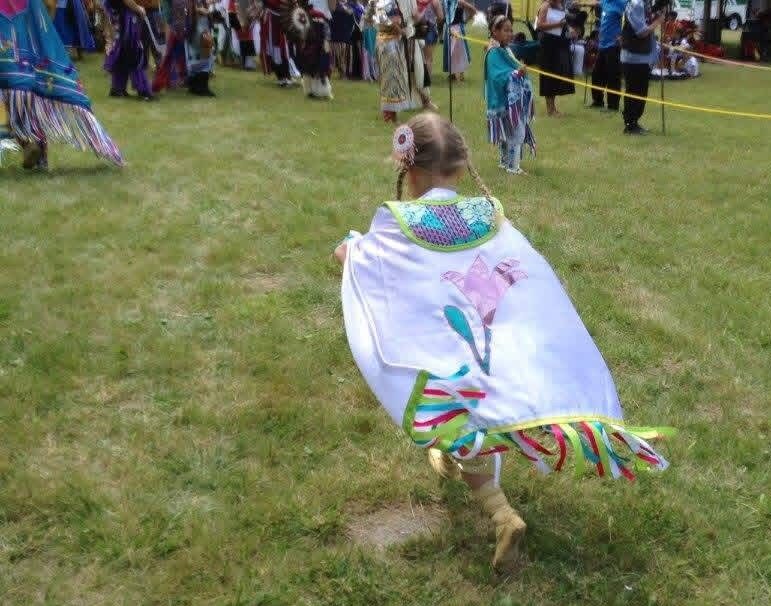 Child running in traditional regalia