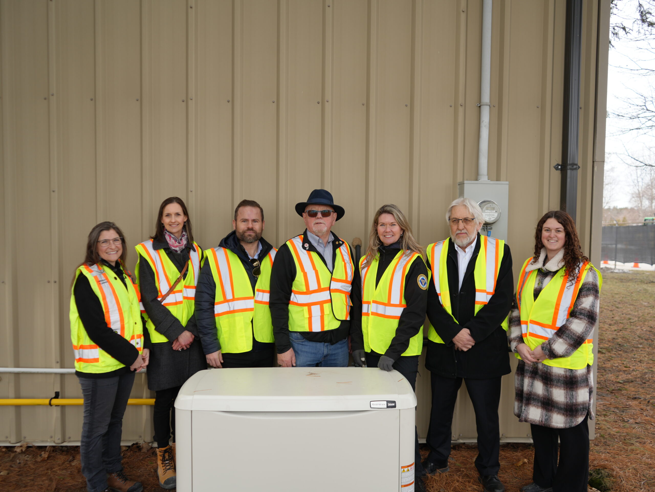 Elected officials and staff pose behind new generator