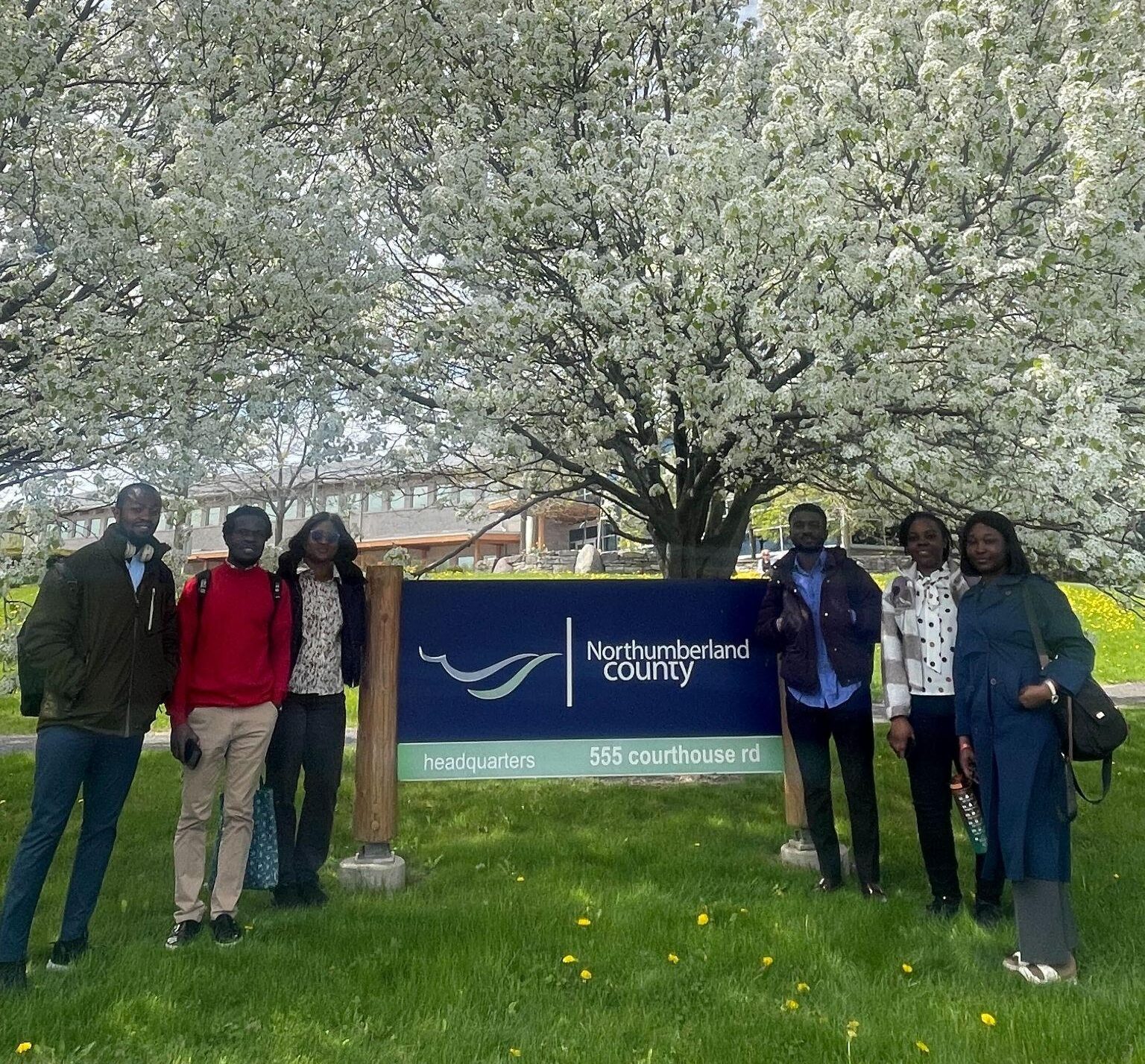 Passages program participants pose next to County sign