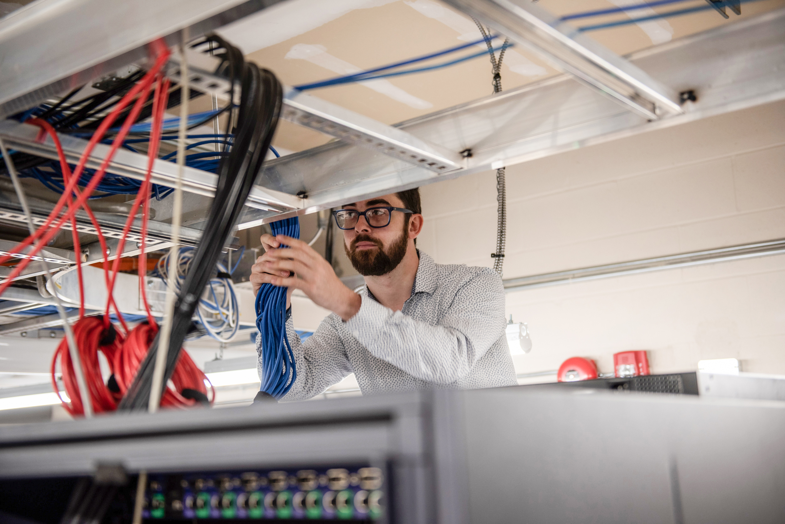IT staff works on wiring in ceiling