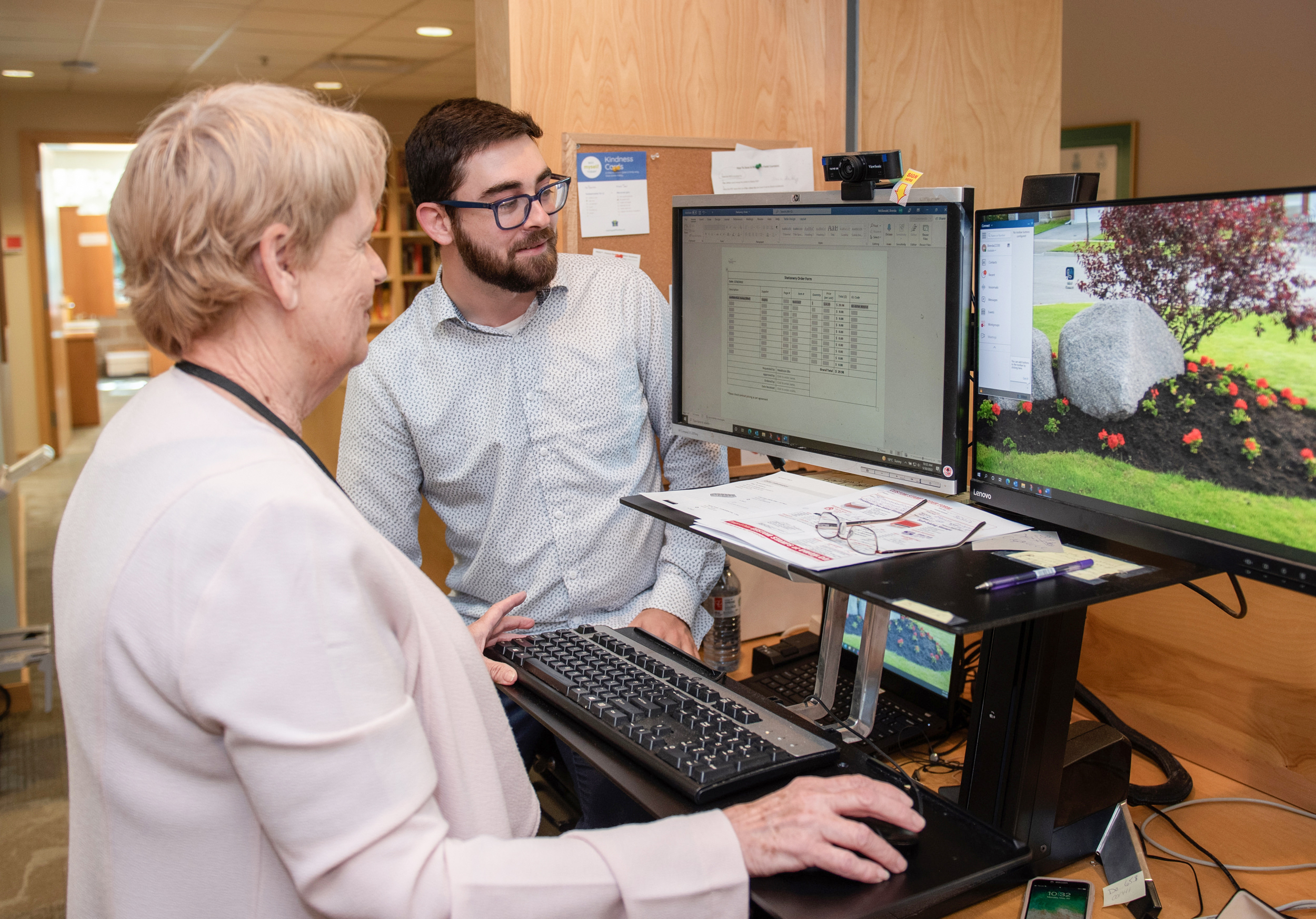 IT staff assists Customer Care staff with their computer