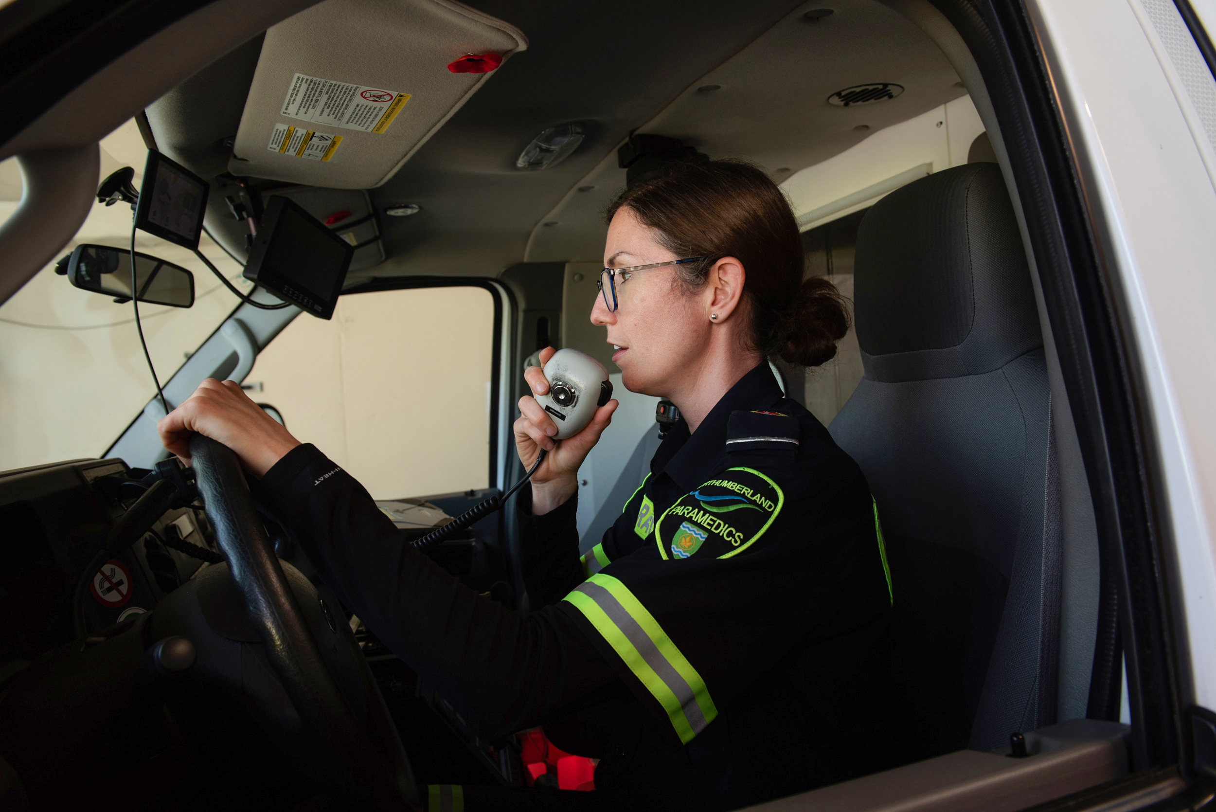 Paramedic speaks into radio in ambulance