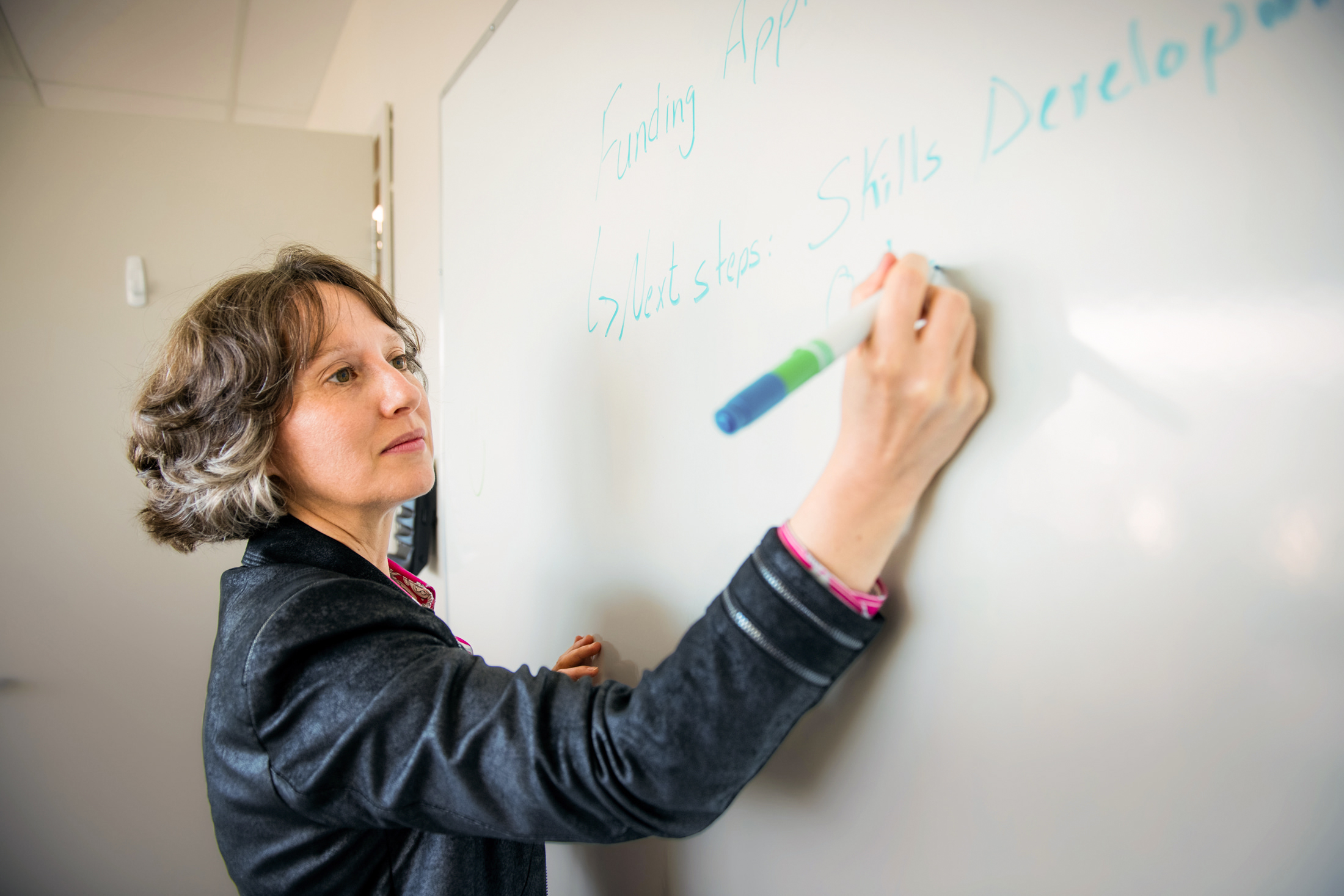 Grant writer writes content on a whiteboard