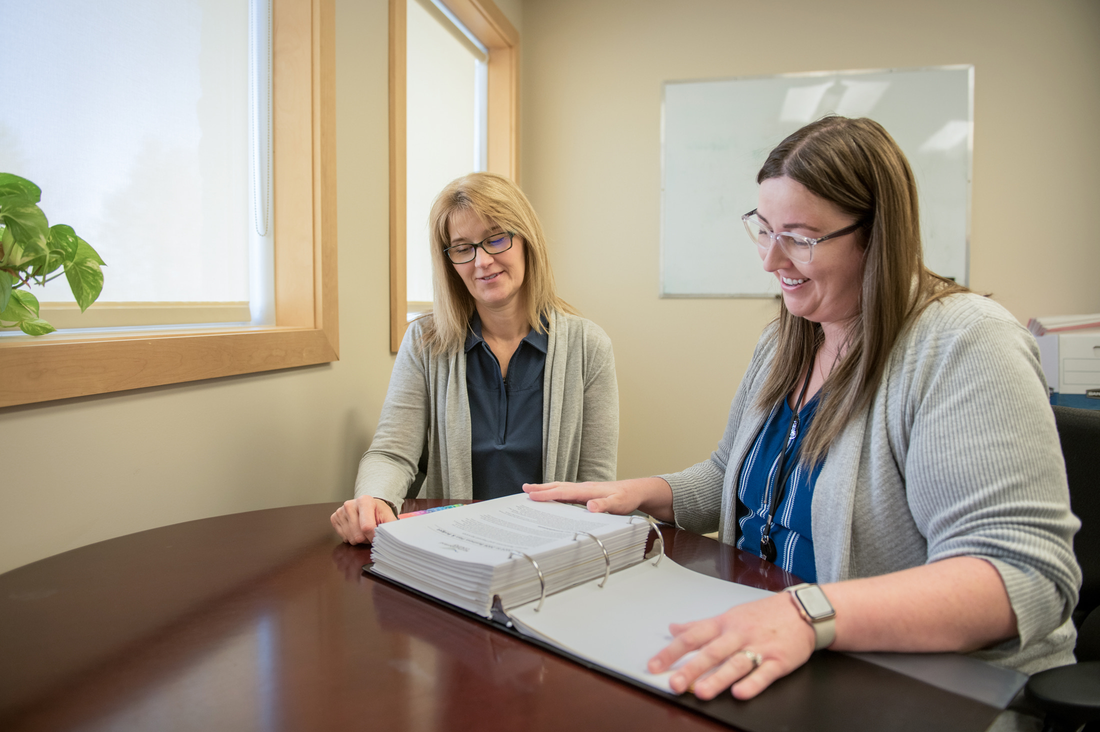 Finance staff members flip through budget binder