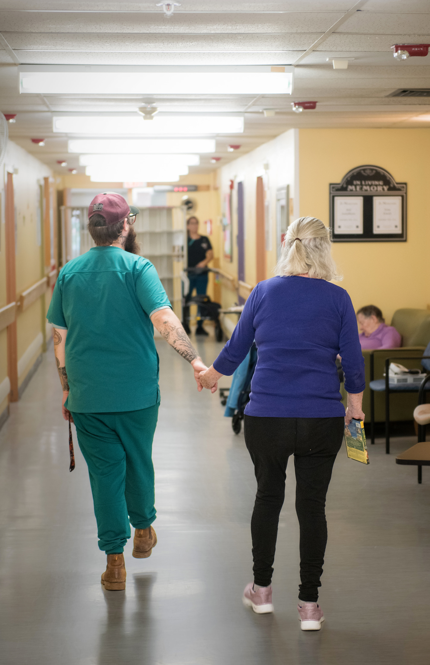 GPL staff walks down GPL hallway with resident hand in hand