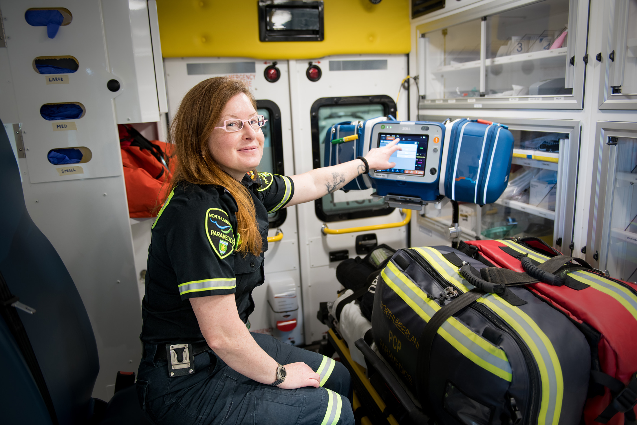 Paramedic operates equipment in the back of an ambulance