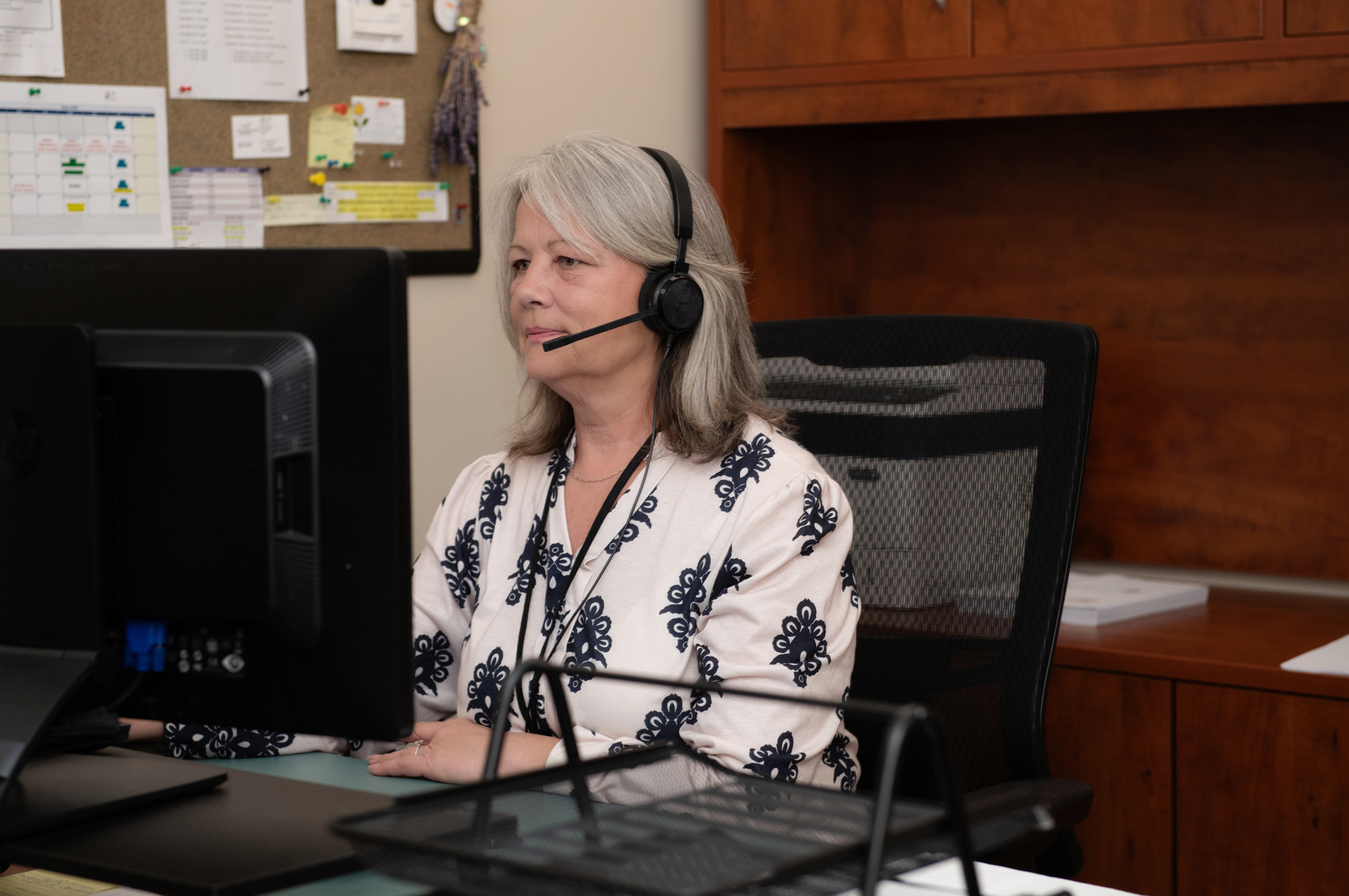 Staff member on call using computer and headset