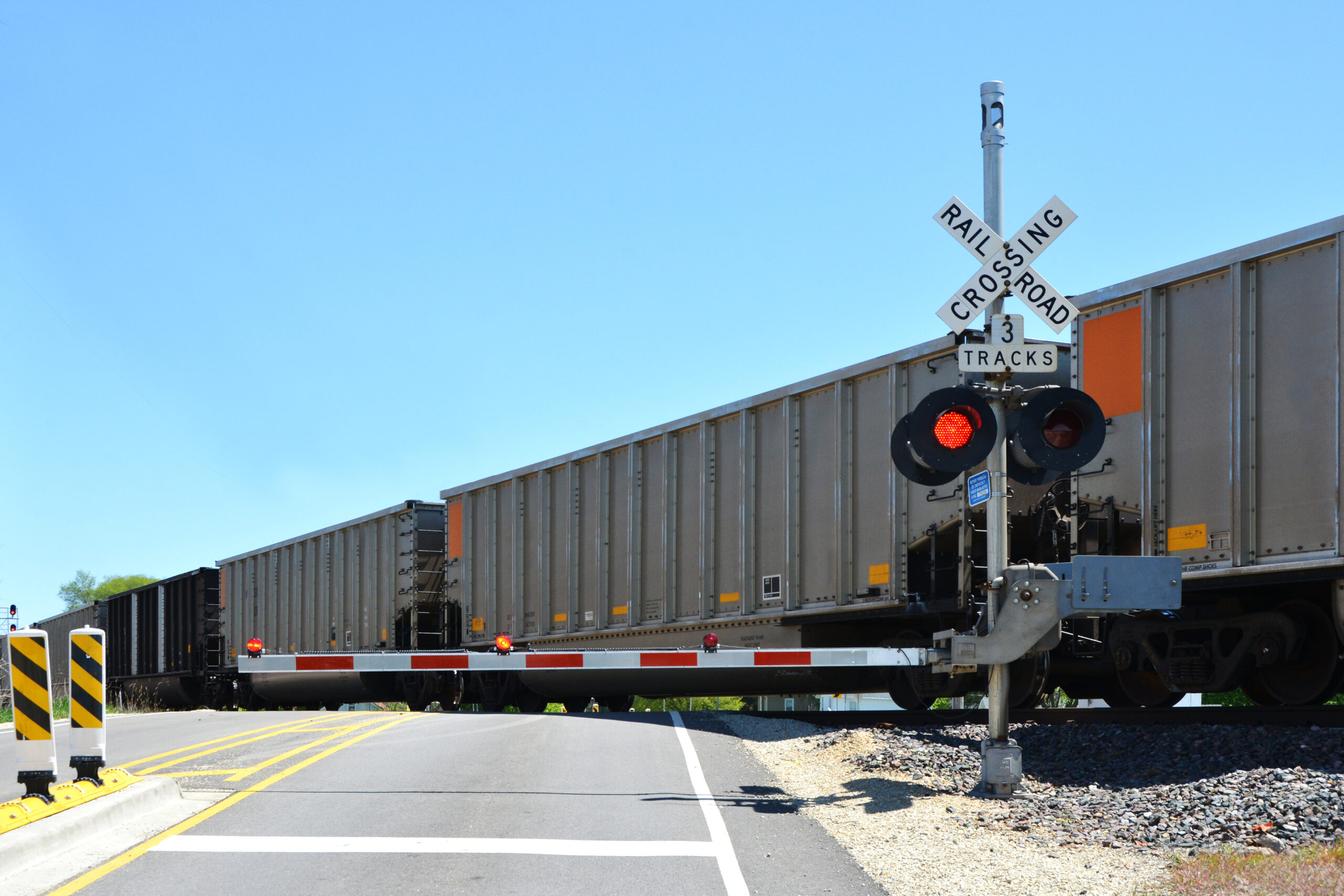Train crossing over a railway crossing with signage.