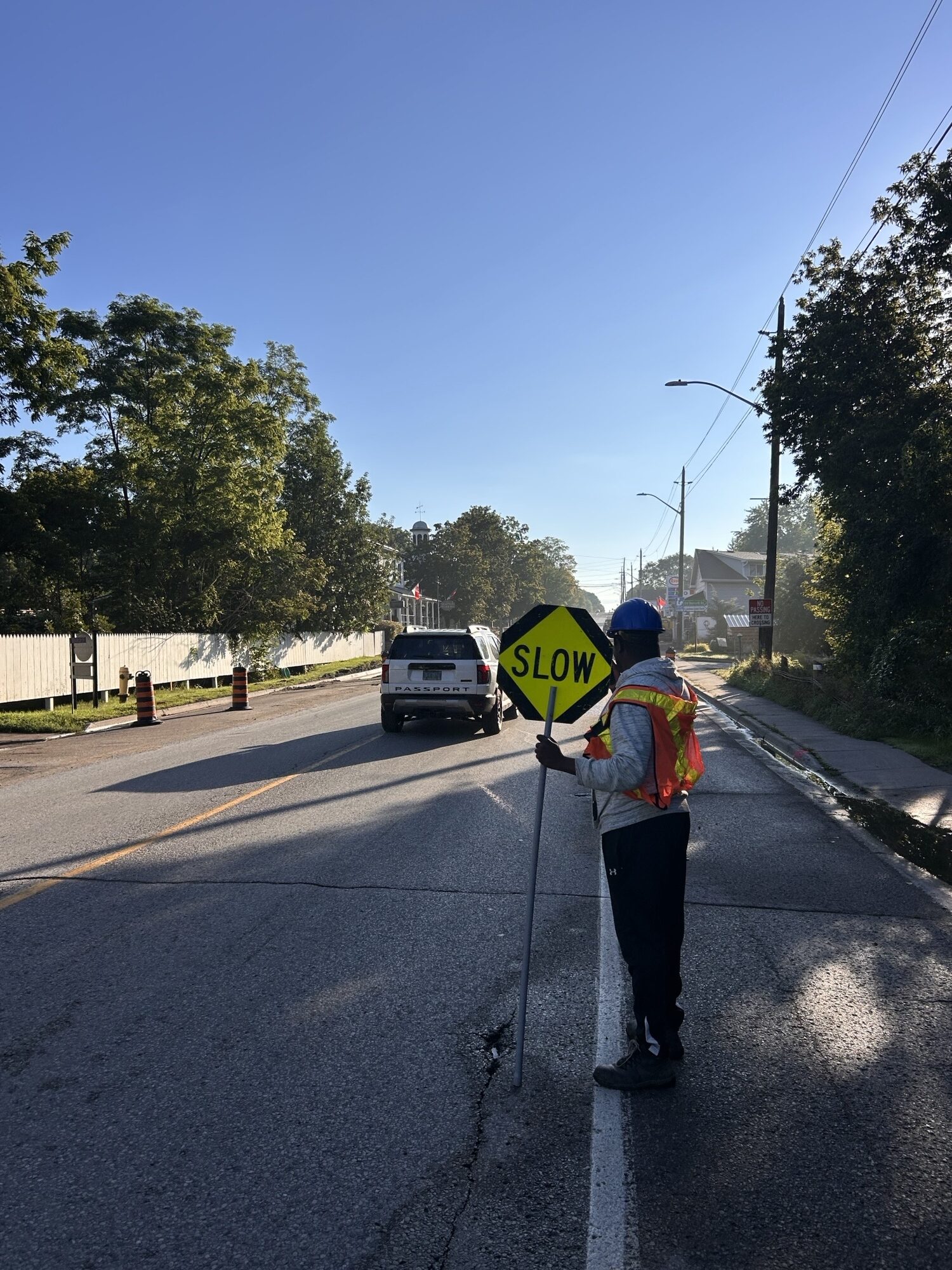 Roads staff holds up a Slow sign at construction site